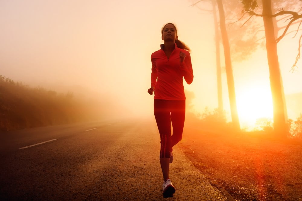 Kvinde på løbetur ved solnedgang